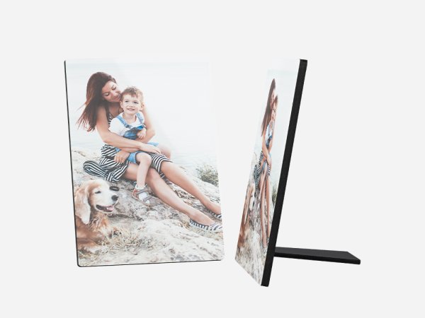 Ein Fotoaufsteller zeigt ein schönes Bild von einer jungen Frau, einem kleinen Kind und einem goldenen Retriever-Hund. Die Frau hat lange, braune Haare und trägt ein gemustertes Top und einen Rock. 