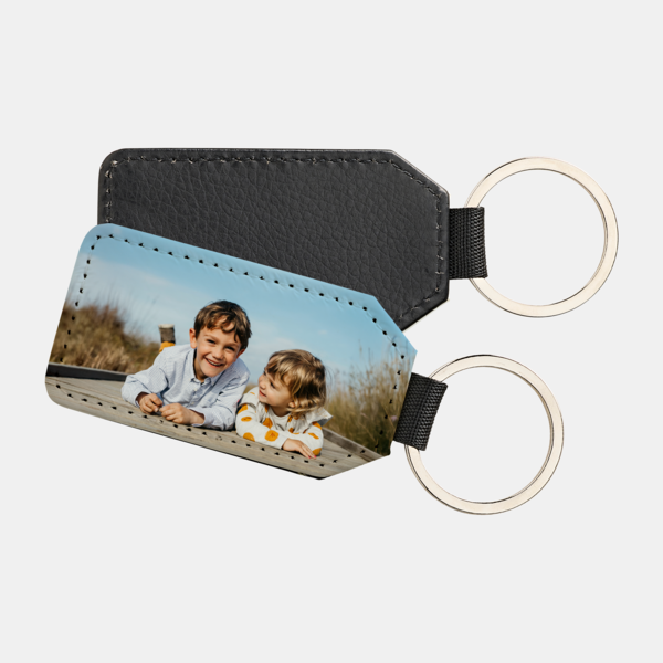 Schlüsselanhänger Flagge mit Foto von zwei Kindern auf Holzsteg, Rückseite aus schwarzem Kunstleder.